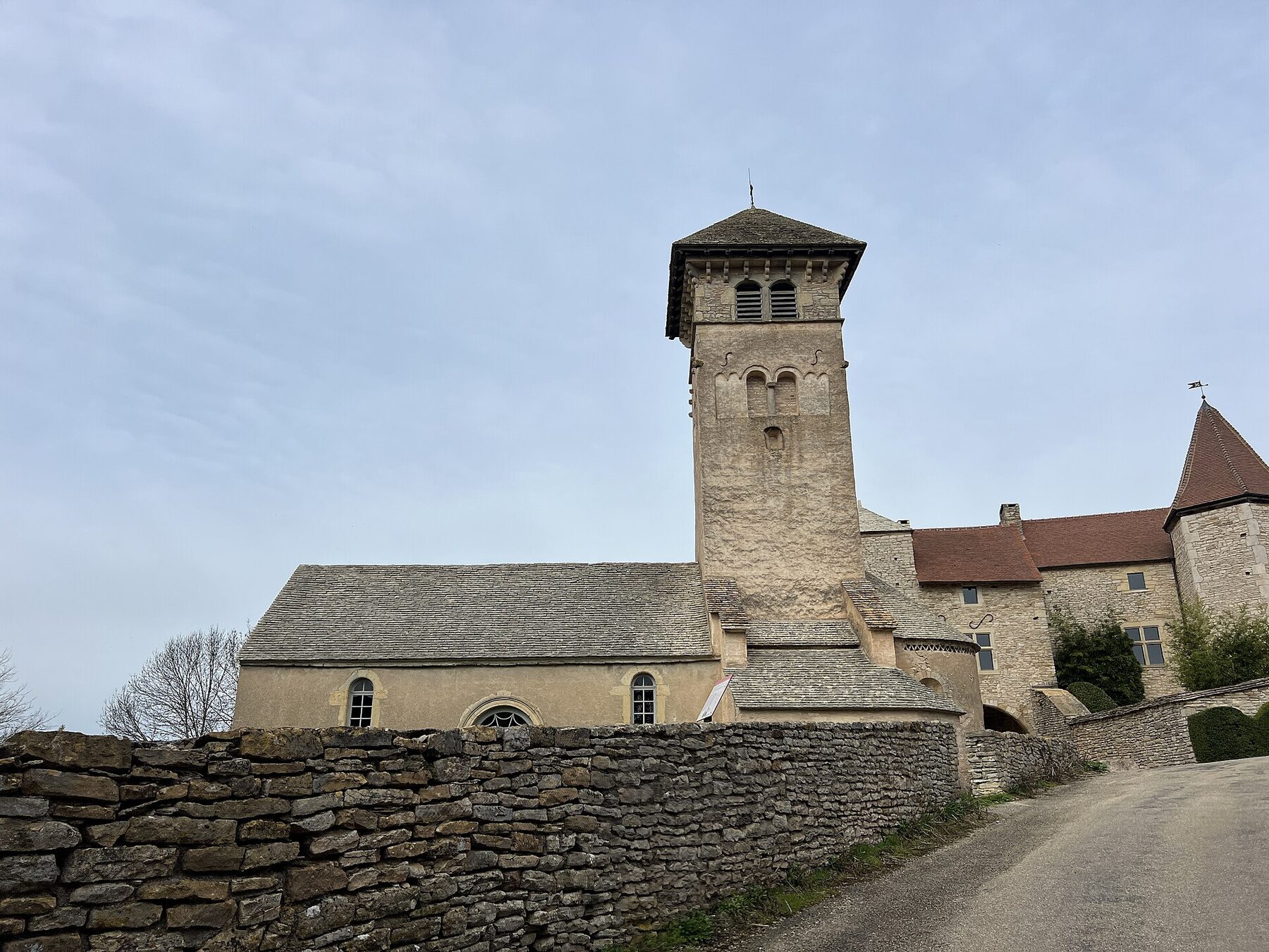 Iglesia románica de Saint-Martin de Blanot vista desde un camino, con su torre cuadrada y muros de piedra