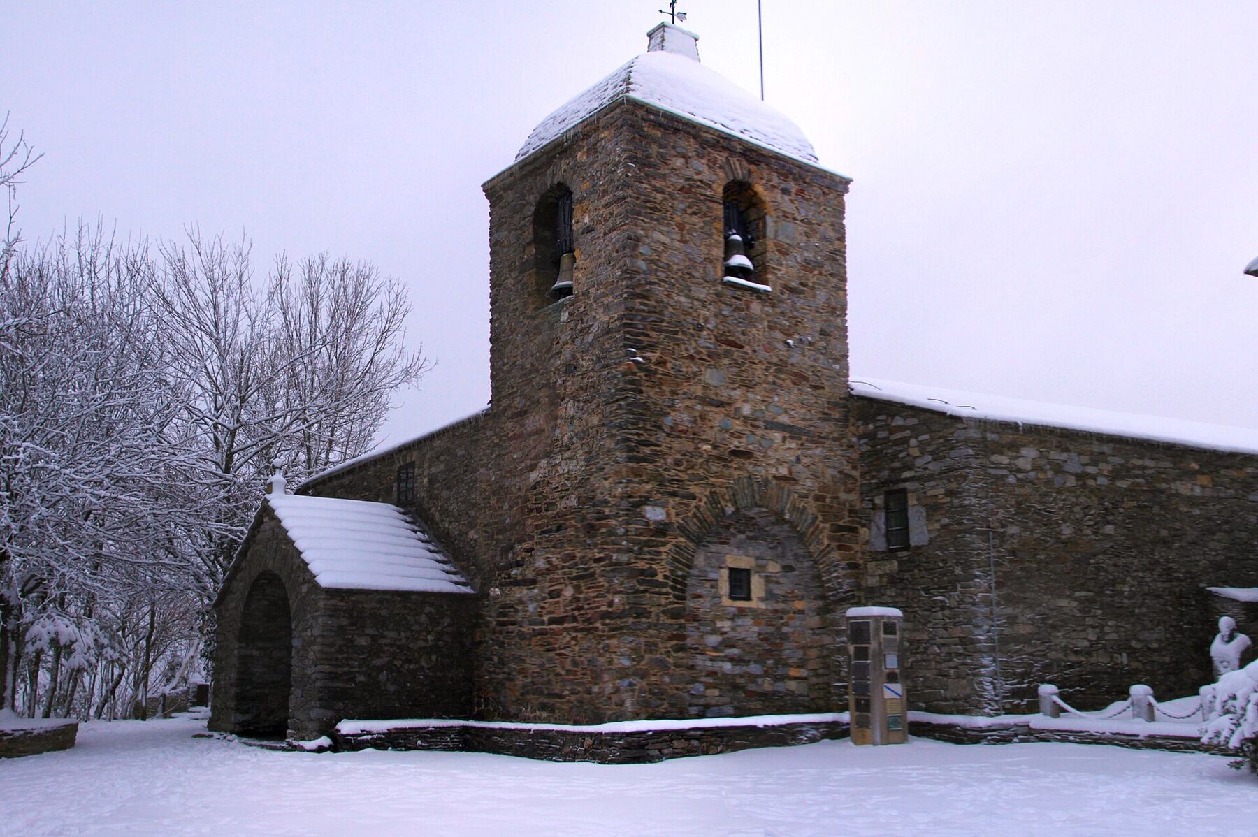 Iglesia de Santa María a Real de O Cebreiro cubierta de nieve, con su torre y muros de piedra