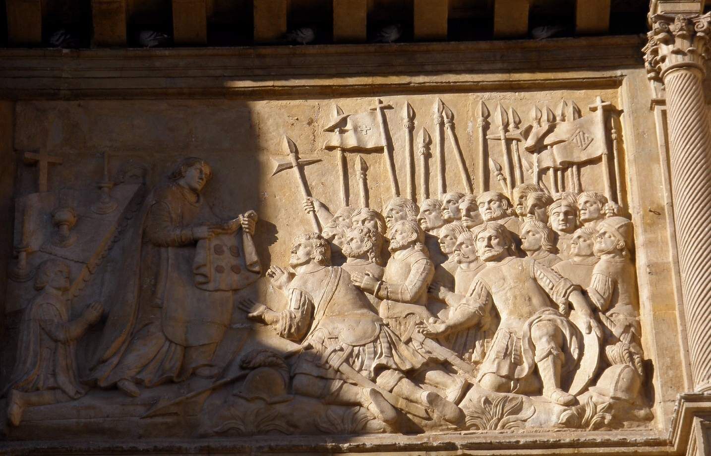 Relieve de piedra en la basílica de los Sagrados Corporales de Daroca, con soldados con lanzas y un sacerdote