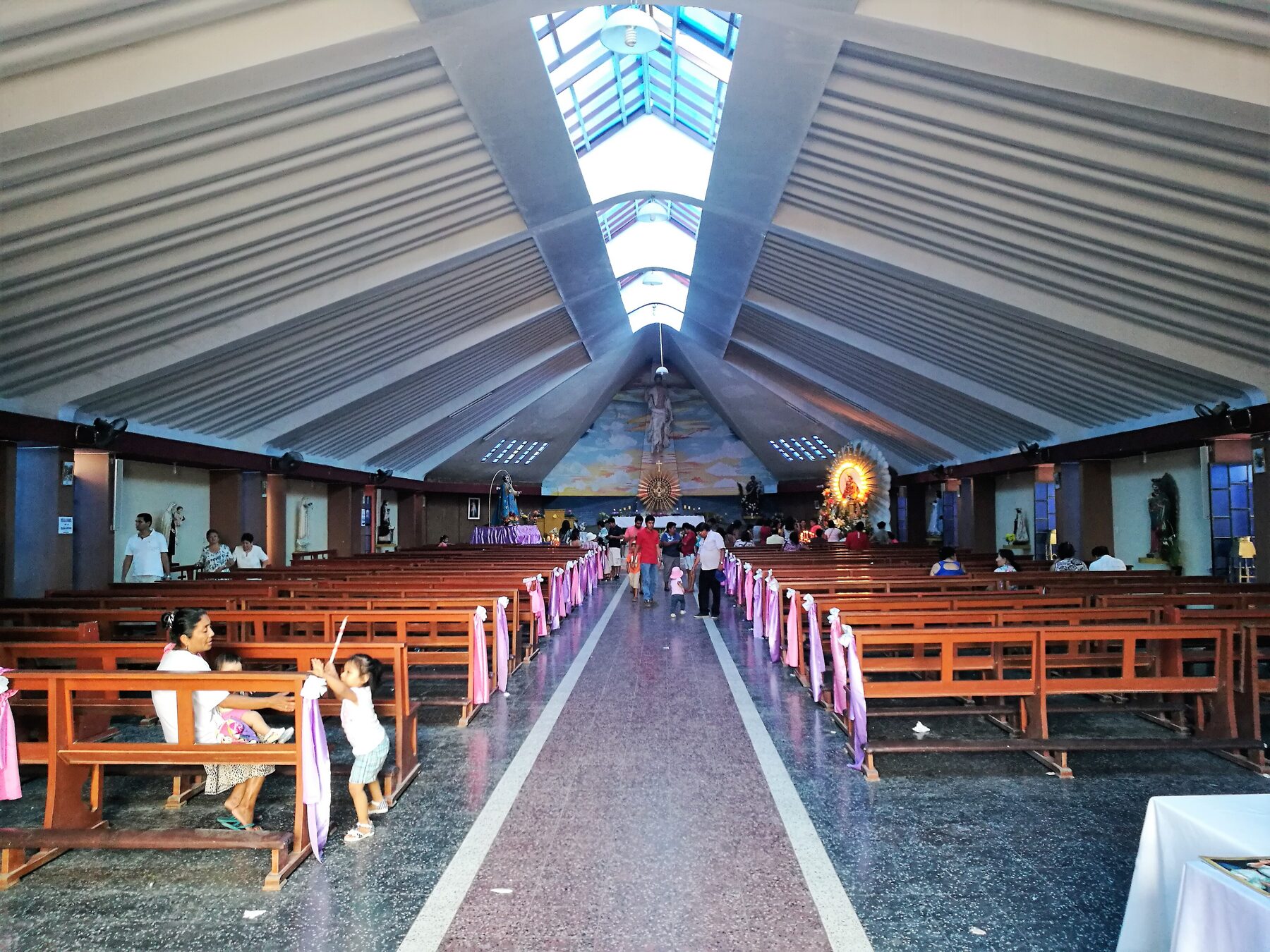 Interior de la iglesia de Santa María Magdalena de Eten, en Perú, con un techo de líneas inclinadas y bancos de madera