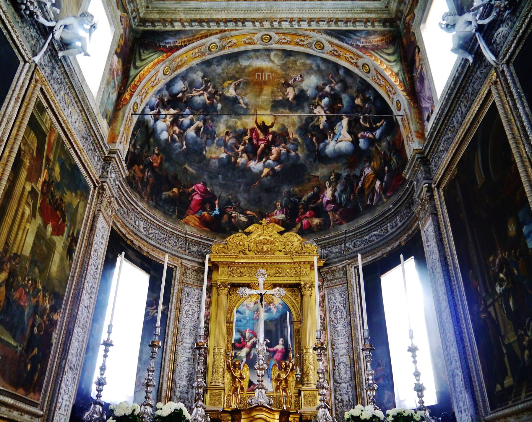 Presbiterio de la basílica de Santa Maria in Vado de Ferrara, con un gran fresco en la bóveda y un altar dorado