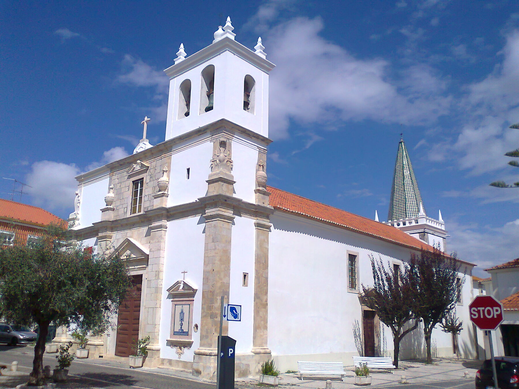 Fachada blanca de la iglesia del Santíssimo Milagre, antigua iglesia de Santo Estêvão, en Santarém, con su torre y tejado rojo