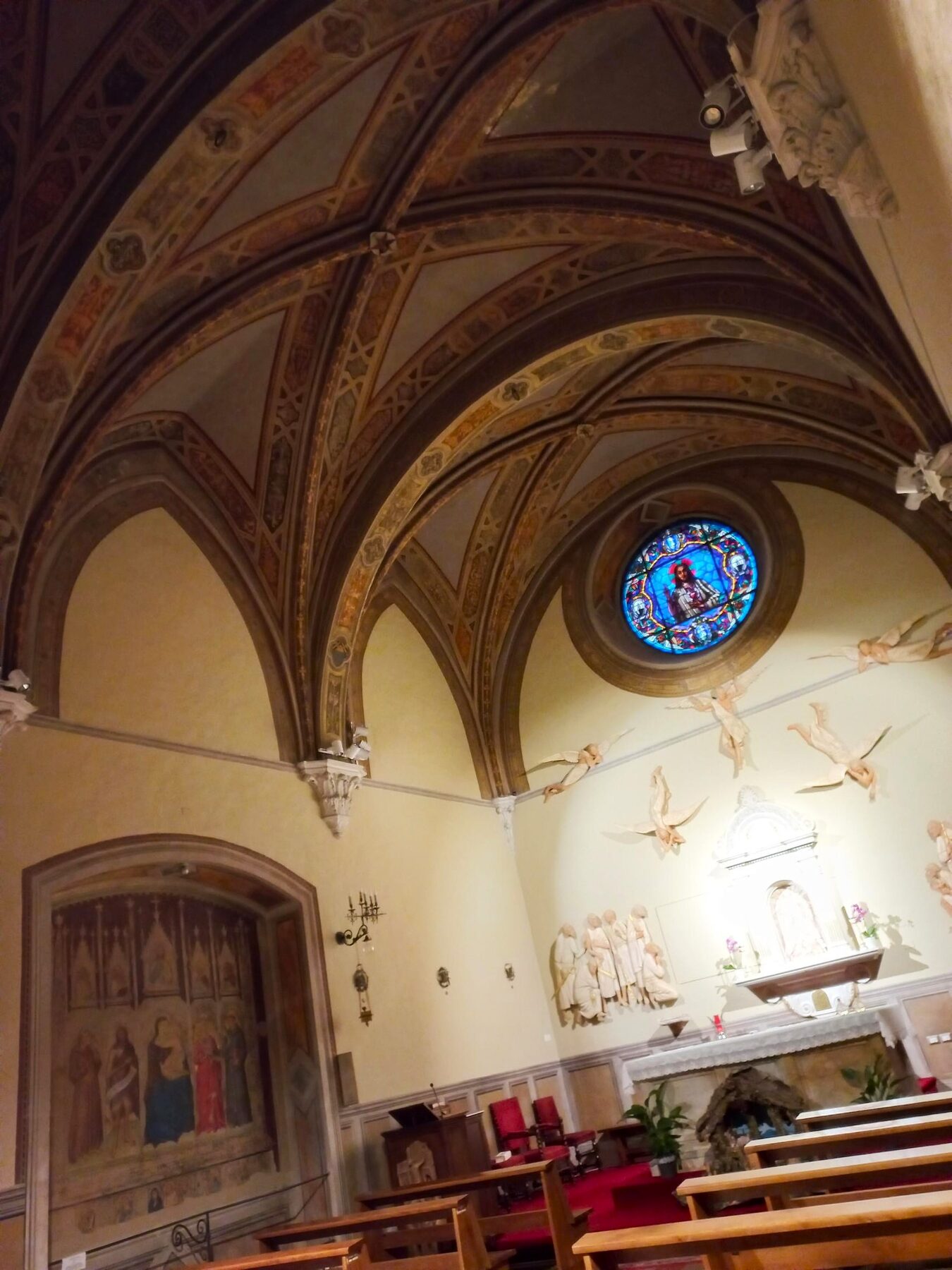 Capilla invernal de las Sagradas Partículas en la basílica de San Francisco de Siena, con bóvedas pintadas y un vitral