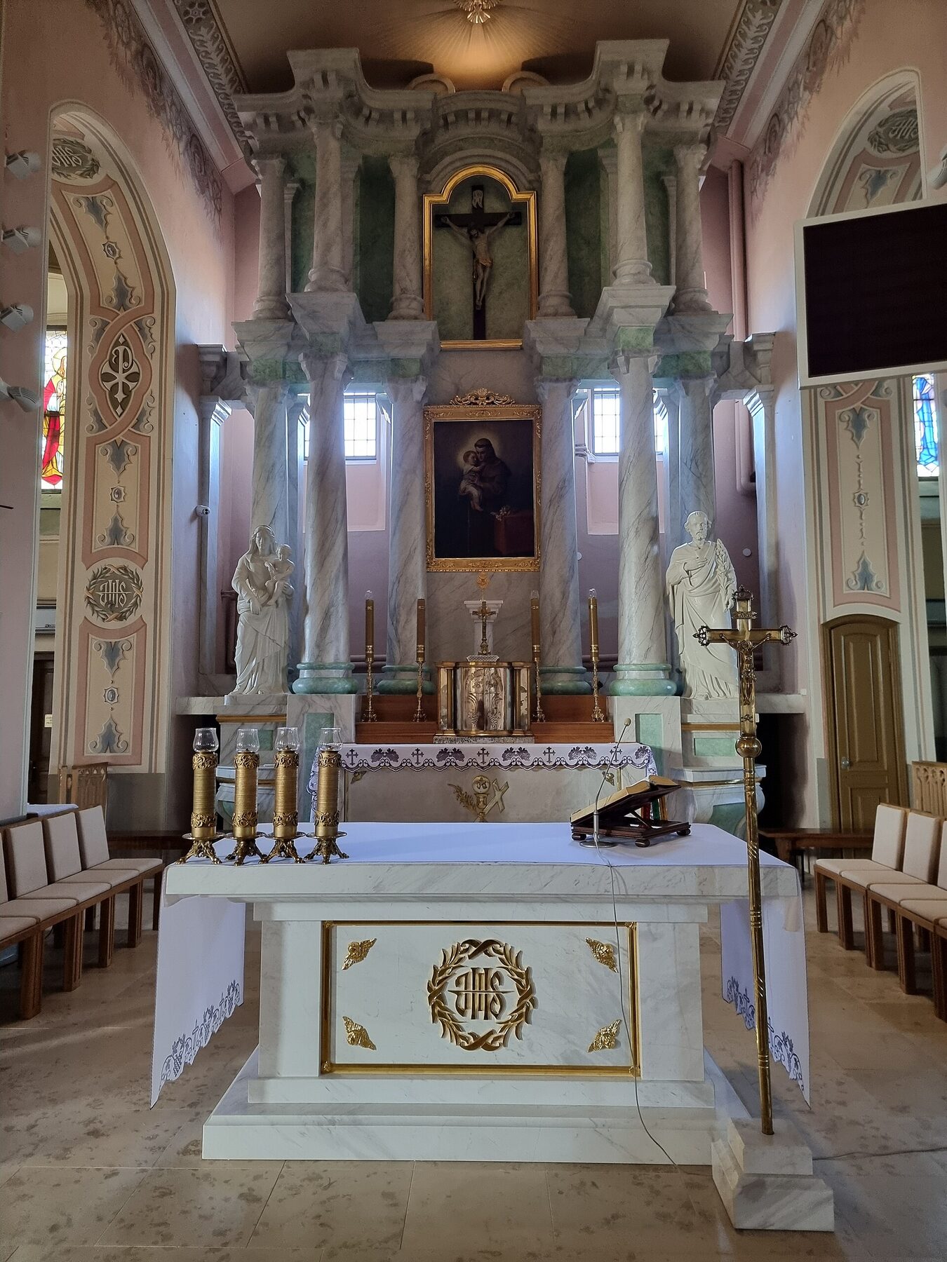 Altar de la colegiata de San Antonio de Sokółka, en Polonia, con columnas y un crucifijo sobre el retablo