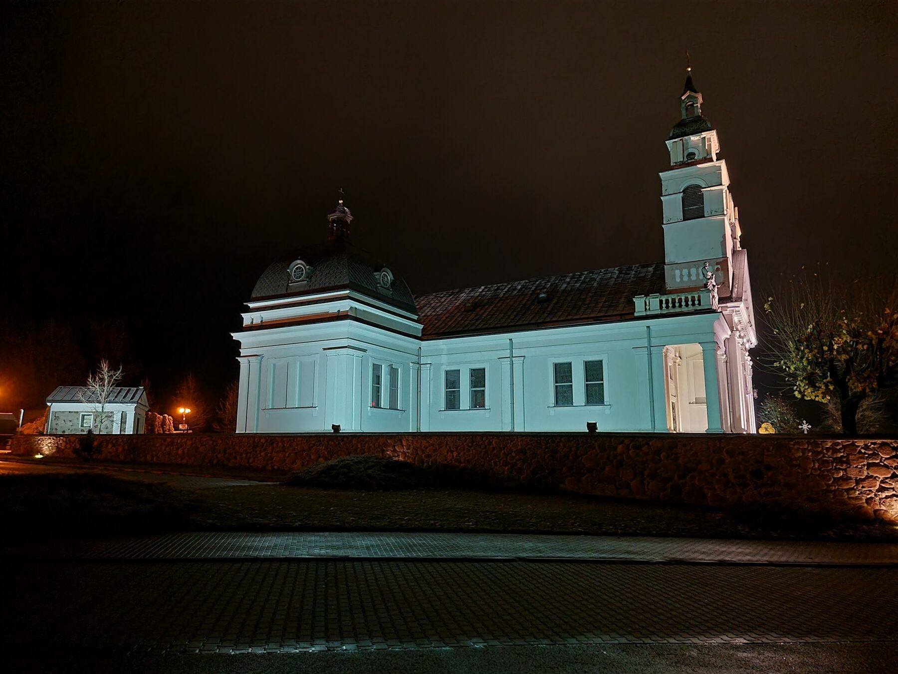 La colegiata de San Antonio de Sokółka iluminada de noche, con su torre y su cúpula