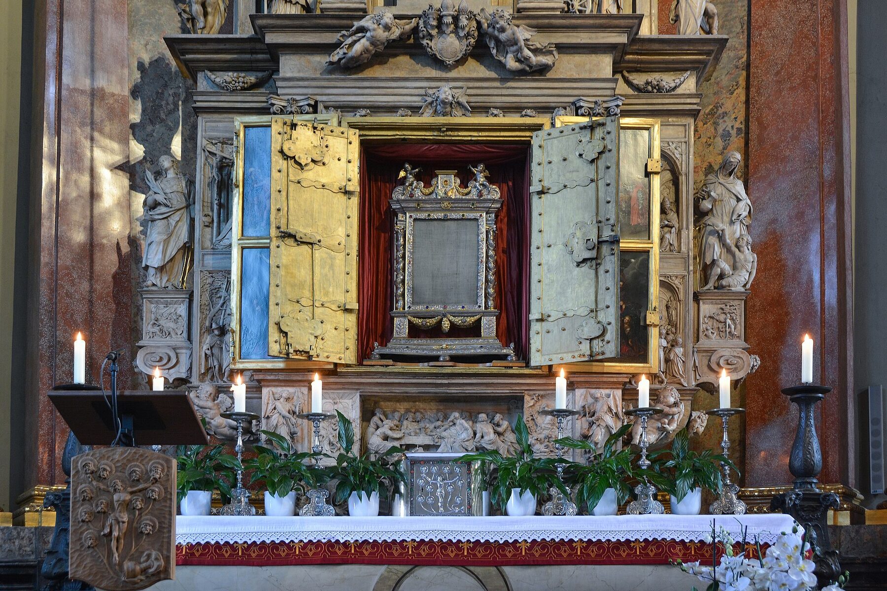 Altar de la Sangre en la basílica de Walldürn, con las puertas abiertas que muestran el corporal en su marco, entre velas y flores